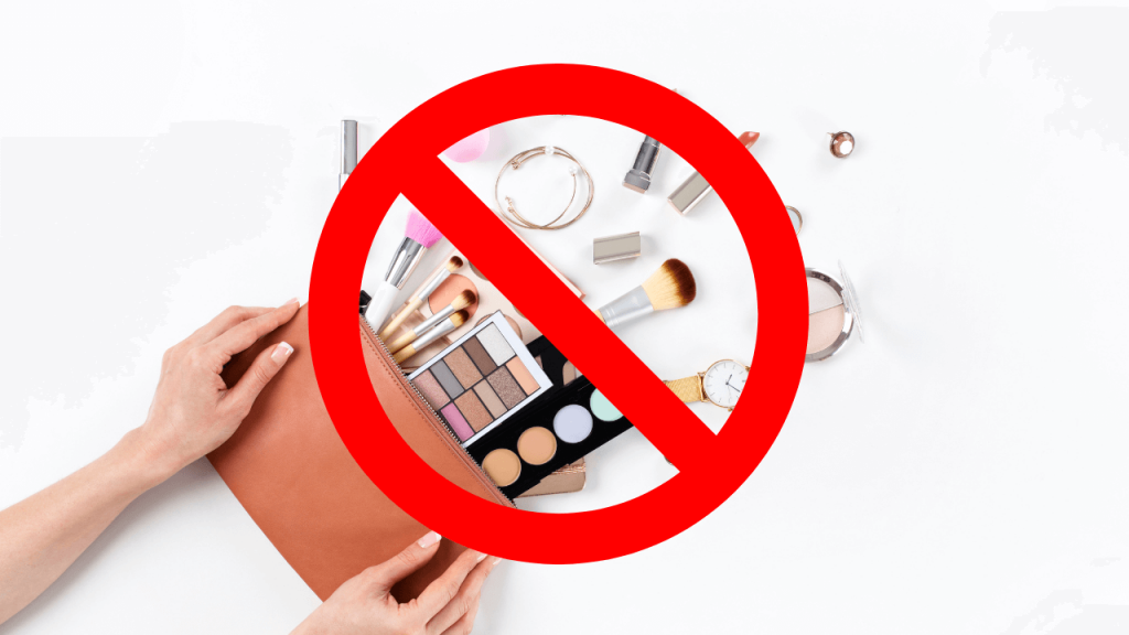 Various makeup cosmetics thrown out of a purse, there is a prohibition sign on top of the cosmetics